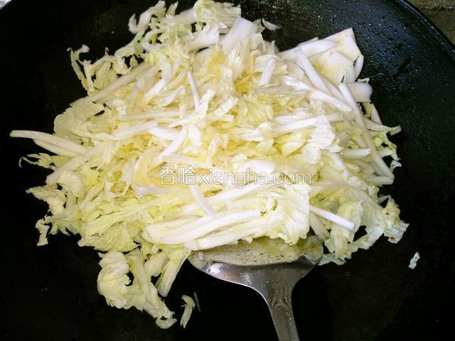 炒肉片的油留锅里，下白菜翻炒至变软。