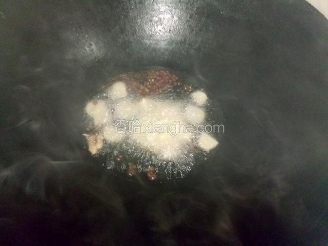 锅中放适量油，下入花椒，姜蒜，炒香。