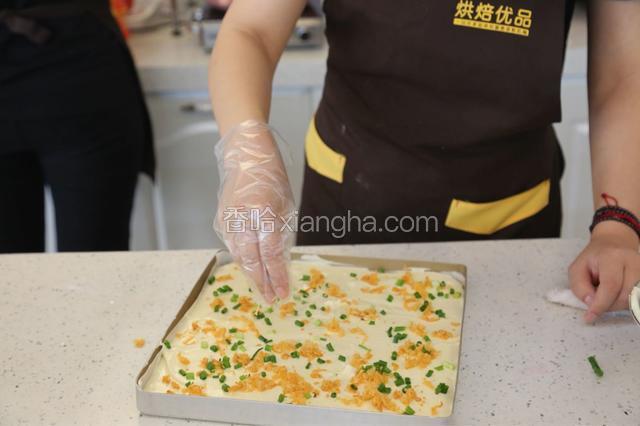 13.在面糊表面撒上葱碎和肉松
