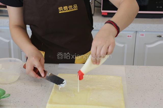 15.将烤好的蛋糕卷反扣脱模，在蛋糕卷反面涂上沙拉酱，抹均匀。
