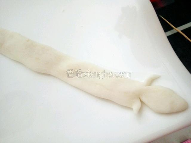 取面团搓成条，尾处剪两下，如图