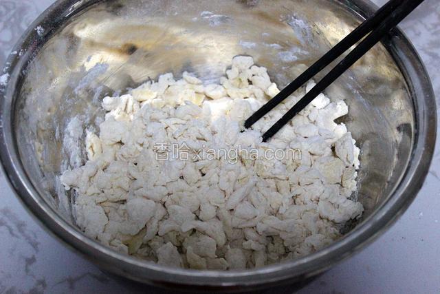 面粉中分次慢慢倒入蛋液水，用筷子不停搅拌至出面疙瘩（蛋液水不要一次全部倒入，要看面粉具体情况分次倒入，若水多可再添加面粉，较大的面疙瘩可以用手揪成小块）