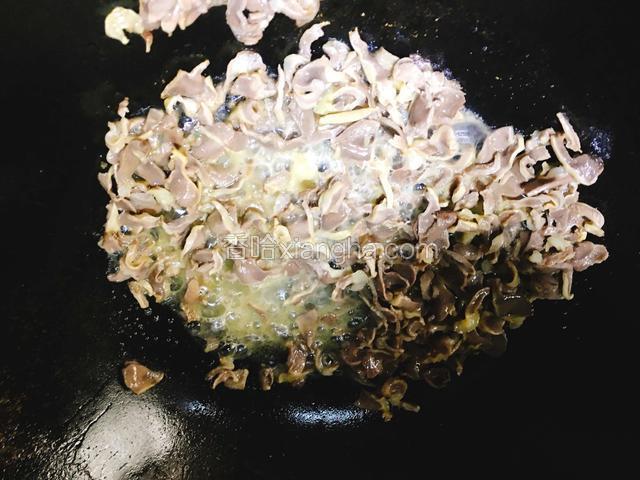 倒入适量的料酒，把鸡胗的水分炒干。