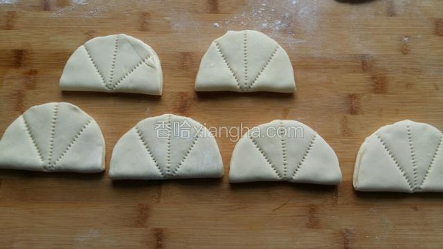 将面饼对折，用没有用过的梳子中间压一下。左右两边再压一下，如图所示。