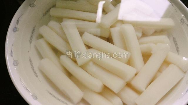 年糕放碗里，用热水泡软。