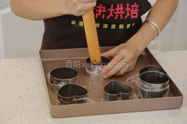 5.用擀面杖将饼干碎压实
