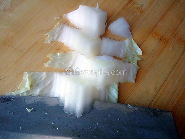 拿一片白菜用刀片成合适的段。