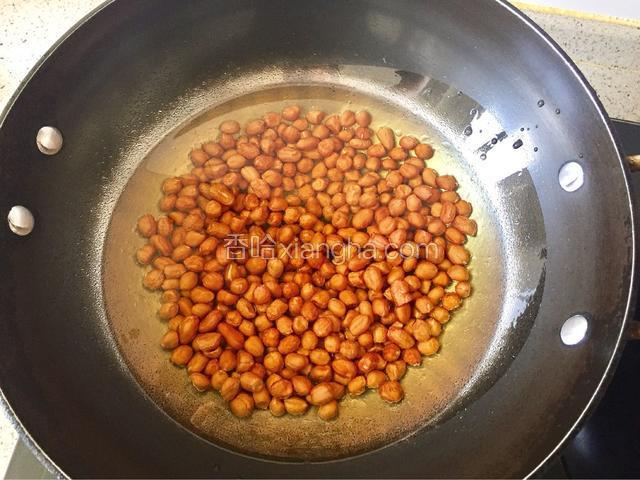 捞出沥干水分倒入冷锅中，加入刚好没过花生米的食用油。（手一哆嗦稍为倒多了一点）