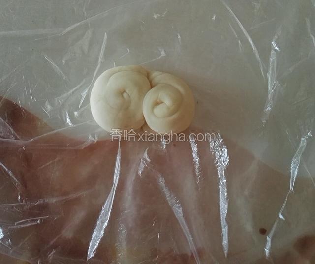 取一份面皮，从中间用筷子按一下，对折，使两边朝上按扁，擀成面皮