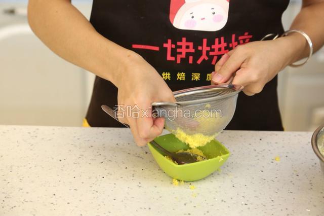 3.将煮熟的蛋黄放在粉筛上，用手指按压，过筛成蛋黄粉末
