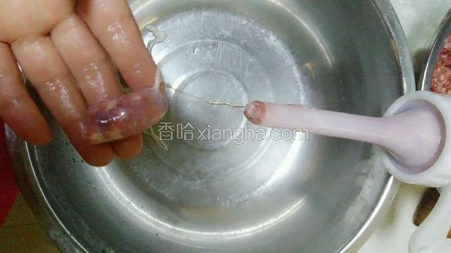 提前泡两个小时的羊肠衣清洗干净，灌水，有较大漏水的地方剪断。灌肠模具装满肉馅，先挤一点到羊肠里，一直推到最后，打结，这时肠衣里粘了油，方便套到管口上