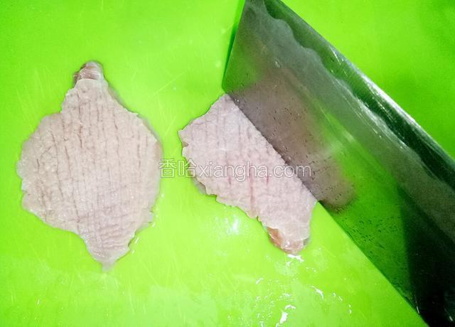 用刀背敲打猪排正反两面，拍松肉质便于入味。