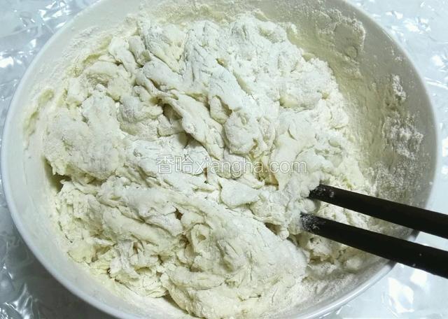 面粉里加入温水，用筷子搅拌成絮状。