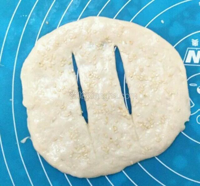 
用刮刀在面饼中间如图划上两道口子。
