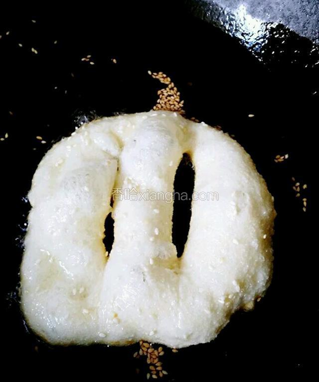 
锅中倒入适量油六七成热后放入油饼小火炸，炸好一面再翻面炸另一面。