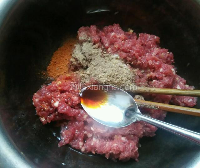 将切好的牛肉放入碗中，用碗中这样大小的勺子放入辅料中的胡椒粉，油，五香粉，盐，料酒和老抽，鸡精拌匀
