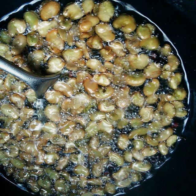待蚕豆米通体金黄，蚕豆碰撞呈清脆声就可关火，捞出沥干油。