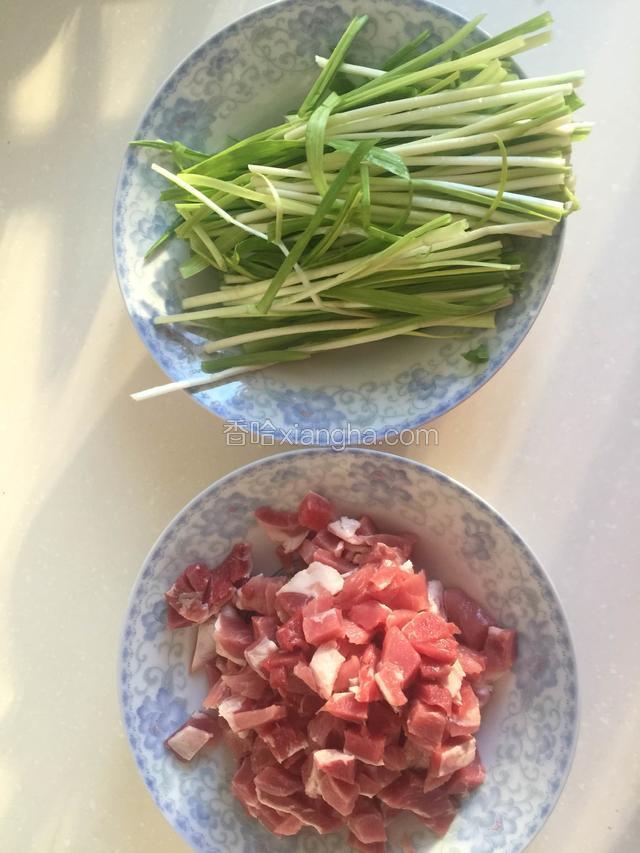 醒面的过程中准备馅料，猪肉的肥瘦比例为2:8，切小块，蒜苗洗净。
