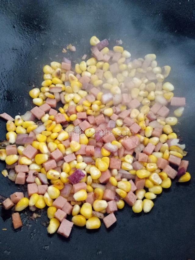 然后放进火腿粒同炒，至玉米全熟。