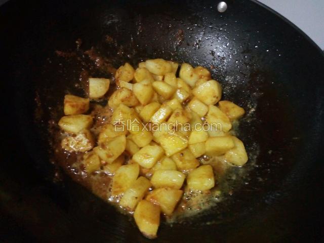 然后倒入炒过的土豆上色入味，保持小火。轻轻翻炒一会。