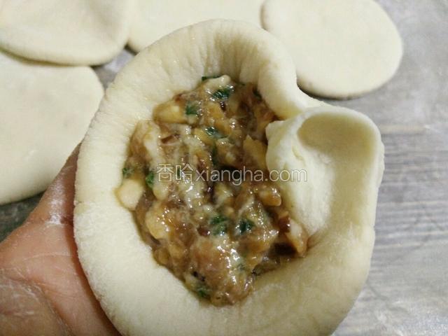 左手托着面饼，右手食指和大拇指从右边开始，顺着边缘往左捏褶皱