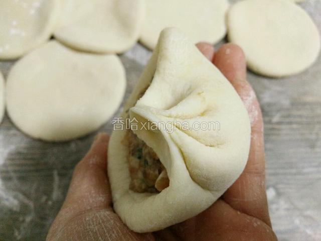 左手托着面饼，右手食指捏褶皱，大拇指跟着转，边转边捏