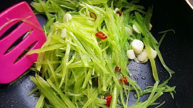 莴苣丝倒入锅内，调大火翻炒一分钟左右。