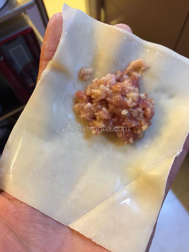 取一皮，皮上两边蘸水，放上肉馅