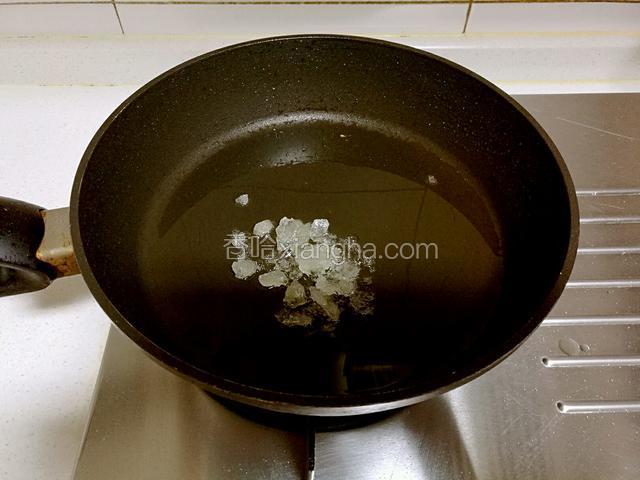 锅中留底油，放入敲碎的冰糖熬糖色。