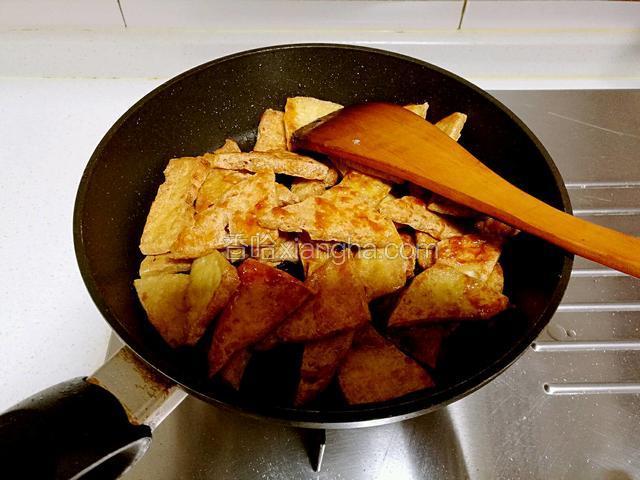 放入豆腐片迅速翻炒上色。