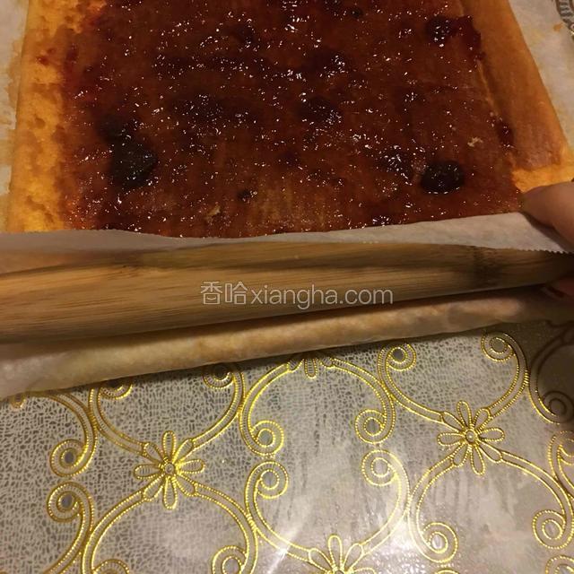 正面朝上，下方垫一张新油纸，借助擀面杖卷起油纸，用力压紧，用油纸带着蛋糕卷向前卷