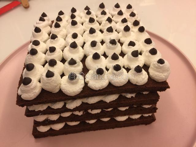 最上面一层挤上奶油，放上巧克力豆装饰