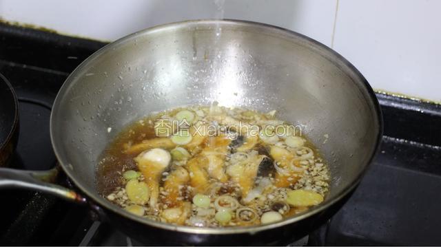 炒出蒜香味后，倒入料酒，少许生抽，醋，糖和鱼块和适量清水，大火烧开转小火炖10分钟