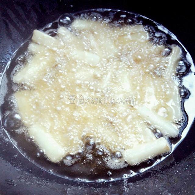 锅烧热多加一些油，用中小火，逐个放进山药条炸制
