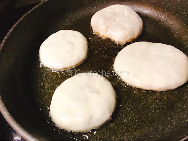 平底锅内倒入少量油，放入馅饼。小火煎制。