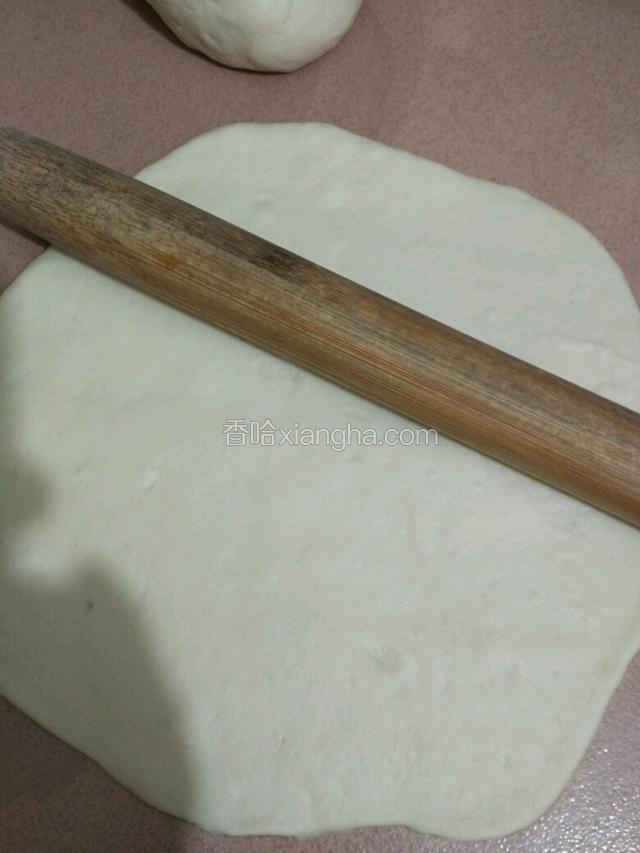 把面团用擀面杖擀成和八寸披萨盘大小的面皮