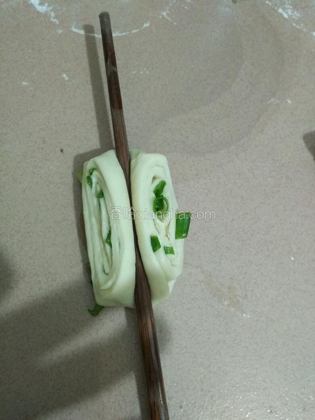 用筷子从中间压下去使两头翻起来