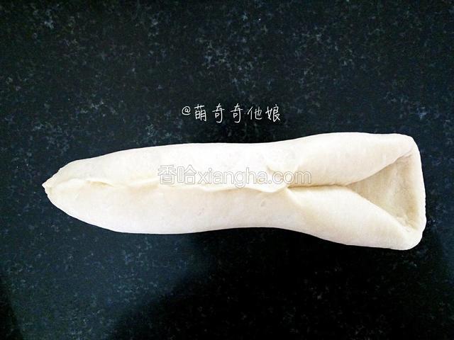 再次对折，以中间重合的那条缝为中心，对折捏紧，如图。