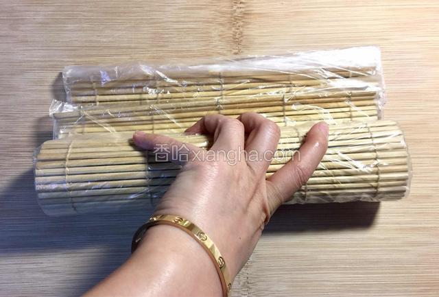 双手均匀用力，继续向前方卷动寿司帘，直到紫菜被全部卷起。（我另一只手在拍照）