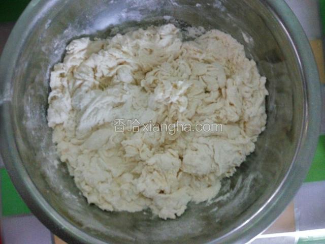 面粉中分次加入适量凉开水，用筷子搅拌成棉絮状