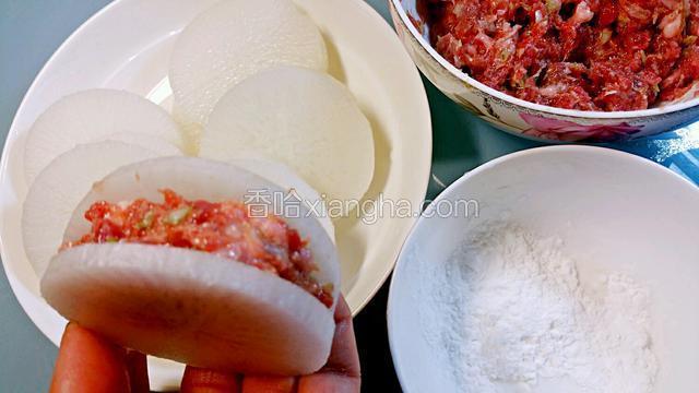 白萝卜里塞入牛肉馅，在萝卜开口处抹一点生粉，这样肉馅不容易滑出来。
