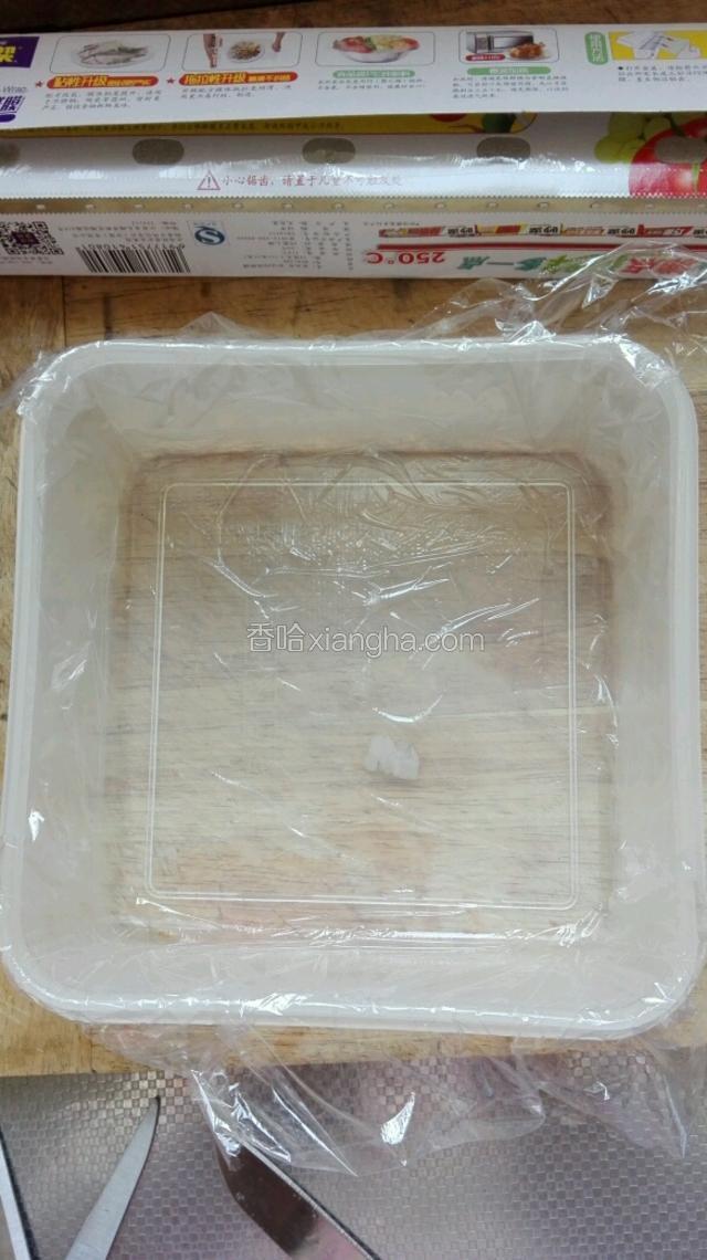 在准备好的方形保鲜盒内，铺上一层保鲜膜。