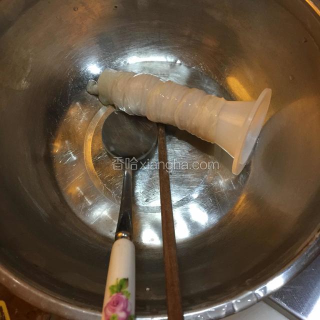 肠衣全部套在灌肠器上，肠尾打结，准备一个勺和一根筷子