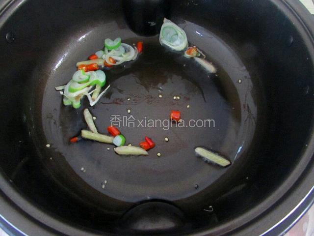 热油炒料
油烧热后，放入葱、姜、小米辣，爆香