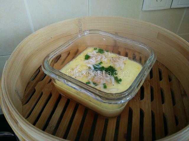 当鸡蛋液凝固一半时，放入虾皮和青蒜叶。