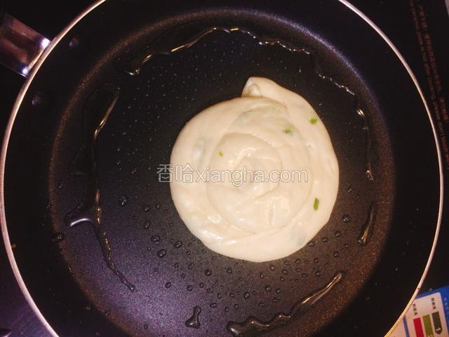 平底锅里刷上食用油，烧热后把饼放进去煎，火要开小一点。