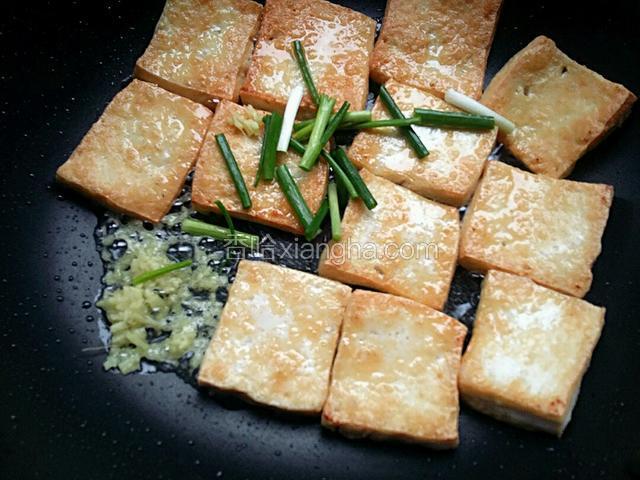 豆腐两面煎黄时，把姜末和葱段倒入锅内，少许煸制，把葱姜的香味煸出