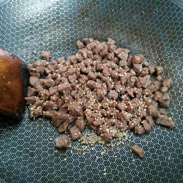 将炒锅烧热倒橄榄油油，下入牛肉丁炒至八分熟，撒上少量白芝麻。