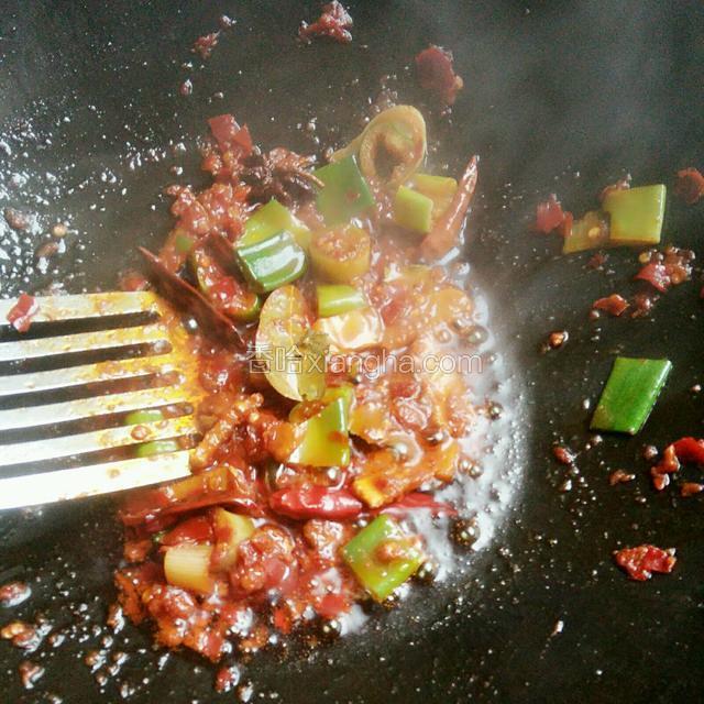 随后放进豆瓣酱和葱炒香
