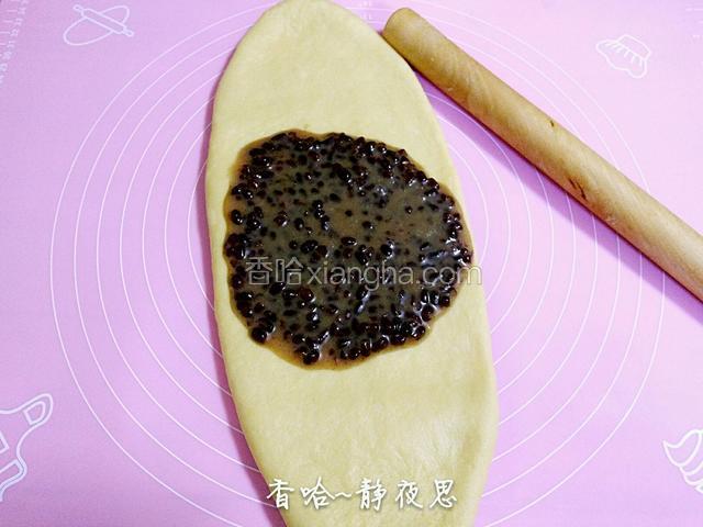 用擀面杖把面团擀开，把混合好的蜜豆放在中间（擀成圆形面皮也行，比较好放蜜豆）